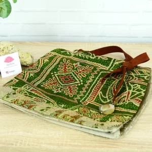 Una bolsa estampada verde y marrón sobre una mesa de madera.