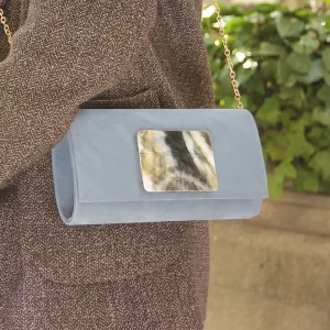Una mujer sostiene un bolso de mano azul.
