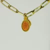 Una cadena de oro con una moneda naranja.