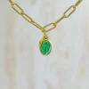 Un collar de oro con una piedra verde.