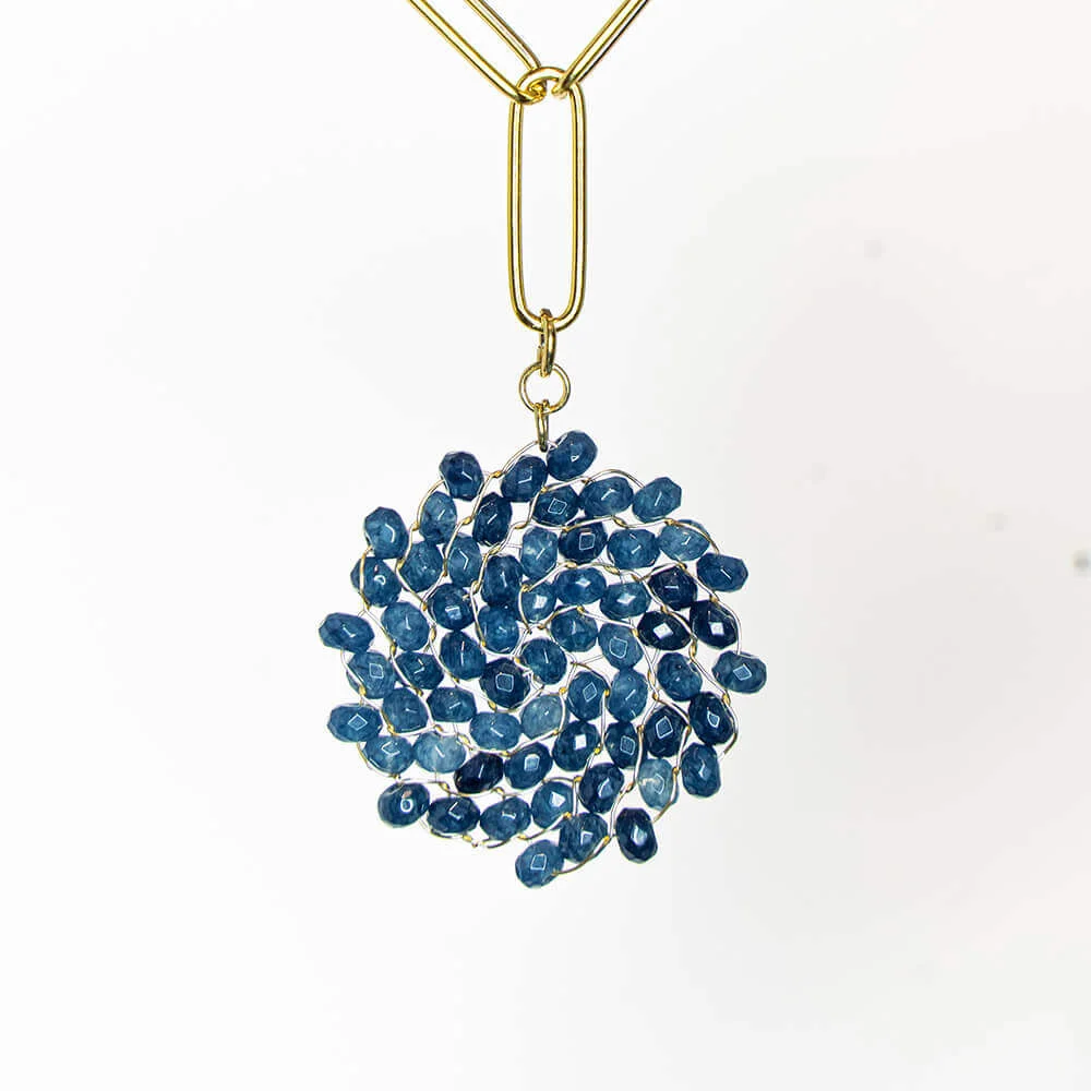 Un collar de cuentas azules sobre una cadena de oro.