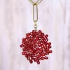 Un collar de cuentas rojas colgado de una cadena de oro.