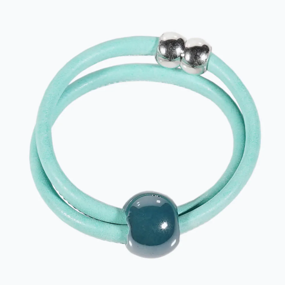 Una pulsera artesanal de cuero porcelana con una cuenta de plata.