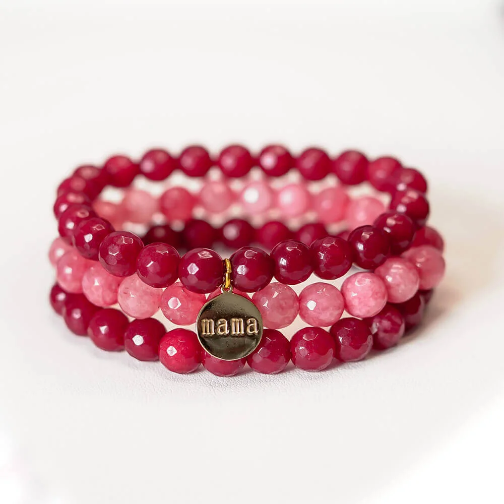 Una pulsera rosa y dorada con la palabra mamá.